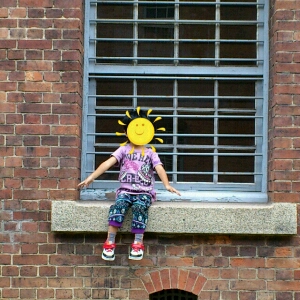 赤れんが倉庫の窓に座り撮影される子供