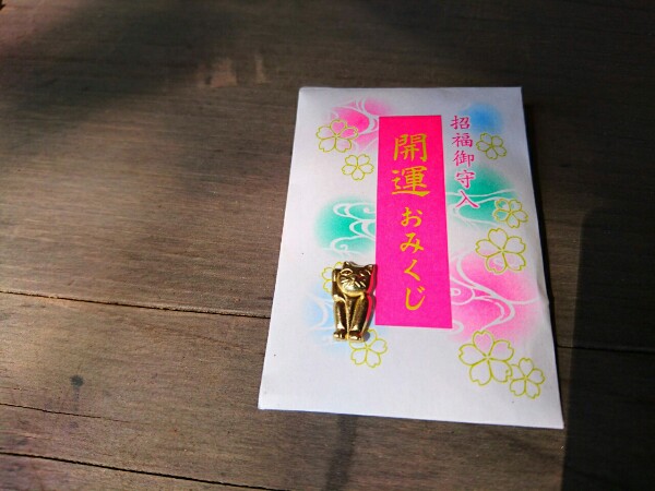 交野天神社の招福御守入開運おみくじ。封筒の中から小さな金の招き猫が出てきた