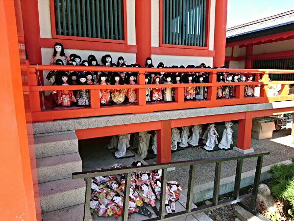 淡嶋神社の拝殿の軒先に沢山の日本人形が置かれている
