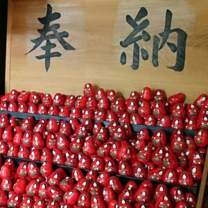 願いを書いた紙をだるまに入れ、願いを叶えてもらう